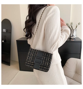 Détail du sac bandoulière en tweed avec chaîne dorée et boucle en cuir noir