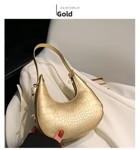 Detail of gold hobo bag with crocodile embossed leather texture and top zipper