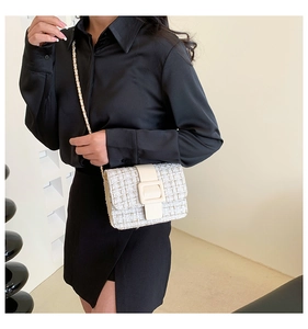 Détail du sac à rabat en tweed blanc cassé avec boucle en cuir et chaîne dorée
