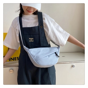 Sac bandoulière en nylon bleu clair porté par un mannequin avec un t-shirt blanc