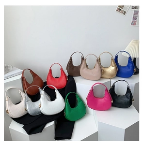 Detailed view of various crescent underarm bags in multiple colors and crocodile patterns