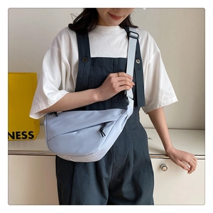 Détail du sac croissant en nylon bleu clair avec bandoulière large et fermeture éclair