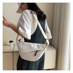 Sac bandoulière beige en nylon avec patchwork géométrique porté par un mannequin