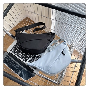 Sacs bandoulière demi-lune en nylon noir et bleu clair présentés dans un décor moderne