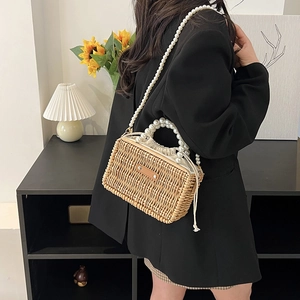Handwoven straw bag with pearl handle and drawstring lining for summer vacation