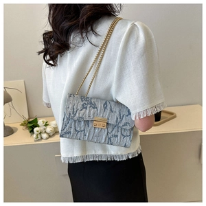 Gray-blue pleated shoulder bag with gold rectangular buckle shown on a model