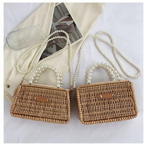 Handwoven straw bags with large pearl handles and long crossbody pearl straps