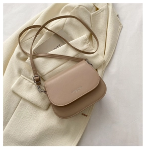 Détail du sac besace kaki avec texture en cuir et boucle en métal argenté brillant