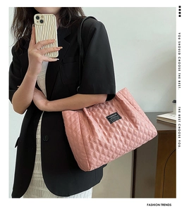 Detailed close-up of pink quilted nylon tote bag featuring fashion label and stitching