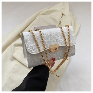 Detail of white pleated oxford bag featuring gold ball chain and rectangular lock