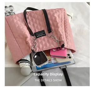 Pink quilted tote bag showing interior capacity with umbrella, sunglasses and gadgets