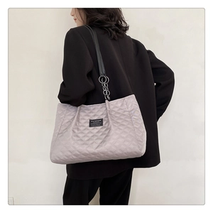 Close-up of light purple quilted tote bag featuring chain straps and fashion label