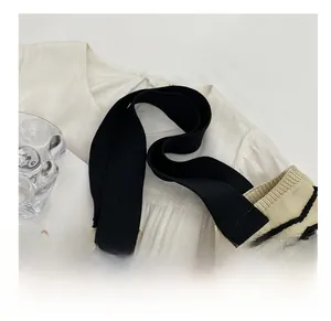 Detail of comfortable wide black knit shoulder strap on wave pattern crochet tote bag