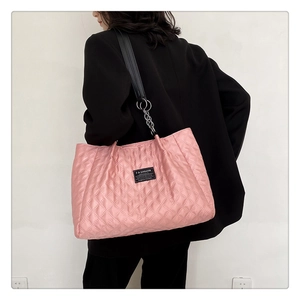 Pink quilted tote bag with diamond lattice pattern and black fashion label detail