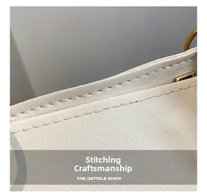 Close-up of premium stitching details and golden metal ring hardware on the beige tote bag