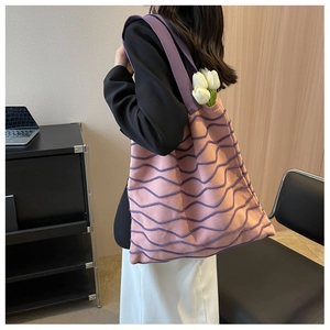 Close-up of pink knitted tote bag with purple wavy stripes and comfortable wide strap