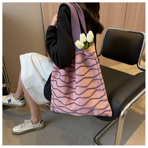 Detail of pink knitted tote bag with purple 3D wave patterns and tulip decoration
