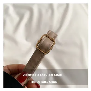 Détail de la bandoulière réglable en cuir beige avec boucle dorée pour cabas