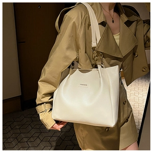 Detail of white minimalist tote bag with golden chain straps and fashion label