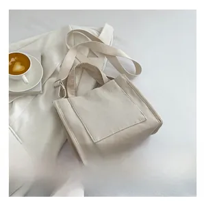 Détail du sac fourre-tout minimaliste en velours côtelé blanc crème avec bandoulière