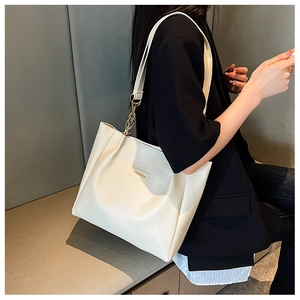 Detail of cream tote bag with gold chain straps and FASHION decorative label