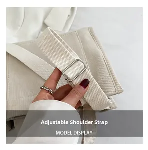 Détail de la bandoulière réglable sur le sac en velours côtelé beige avec boucle métal