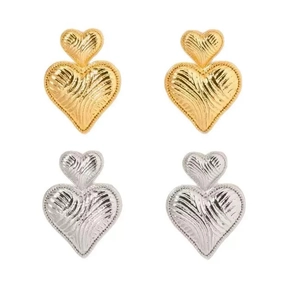 Detail of gold and silver heart earrings with radial texture and beaded edges
