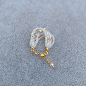 Elegante bracciale multistrato con perle e sfere dorate con chiusura a scorrimento regolabile