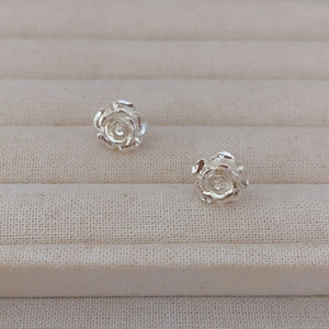 Boucles d'oreilles roses en argent avec pétales texturés sur un plateau de bijoux
