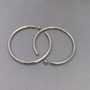 Minimalist C-shaped silver hoop earrings with hollow metal design and mirror-like finish