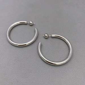 Fashionable C-shaped silver hoop earrings with polished mirror finish and stud closure