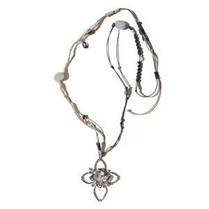 Long woven necklace with hollow branch flower pendant and purple bead accents on white background