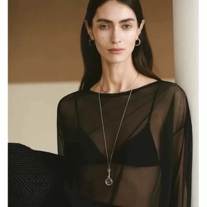 Minimalist gold-plated magnifying glass necklace and hoop earrings set on fashion model