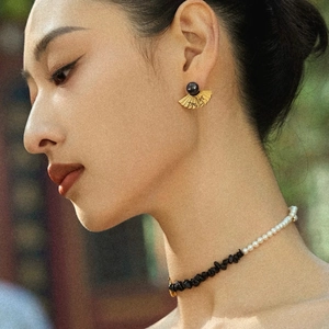 Elegance of Chinese fan earrings and pearl necklace set on model in outdoor natural light