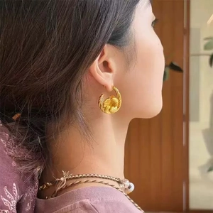 French vintage floral knot earrings in gold plated metal on model for elegant style