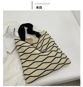 Detail of cream white knitted tote bag featuring black wave texture and soft knit pattern