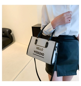 Détail d'un sac cabas minimaliste noir et blanc avec l'inscription Hello Weekend imprimée