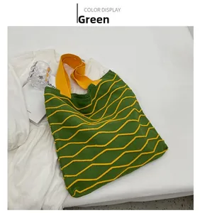 Detail of green knitted tote bag with yellow wavy stripes and vibrant yellow handles