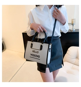 Détail du sac cabas minimaliste montrant l'imprimé 'HELLO WEEKEND' et la bandoulière