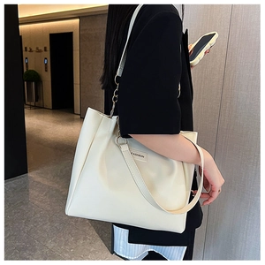 Close-up of cream faux leather tote bag with Fashion label and shoulder strap detail