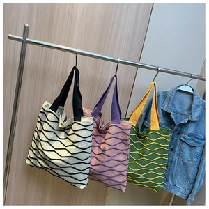 Close-up of knit tote bags with unique wavy patterns in multiple color combinations