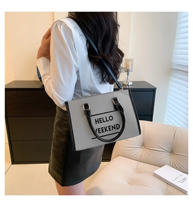 Vue détaillée du sac cabas gris avec texte Hello Weekend et anses noires cylindriques