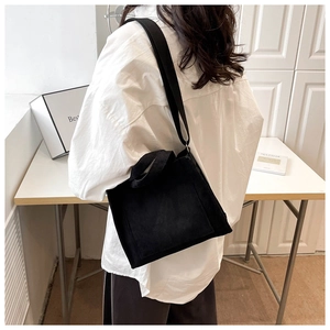 Gros plan d'un sac cabas en velours côtelé noir avec texture rayée et bandoulière large