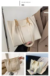 Detail view of off-white tote bag with lychee texture and gold chain fashion hardware