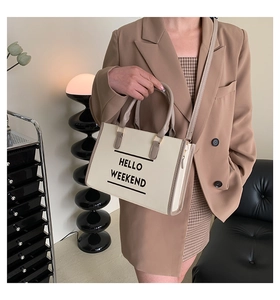 Détail du sac cabas beige avec texte HELLO WEEKEND et bandoulière amovible réglable