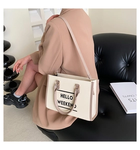 Détail du sac cabas crème avec imprimé Hello Weekend et poignées marron chic en style