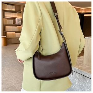 Detail of dark brown matte leather hobo bag with fashion bag text and adjustable strap
