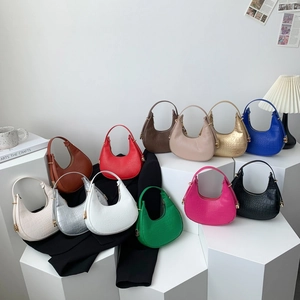 Minimalist crocodile pattern crescent hobo bags in multiple colors on a white pedestal