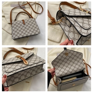 Detail of vintage square handbag showing clover pattern, leather handles and golden hardware