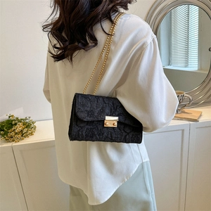Women's black Oxford chain bag with pleated texture and gold hardware worn by model